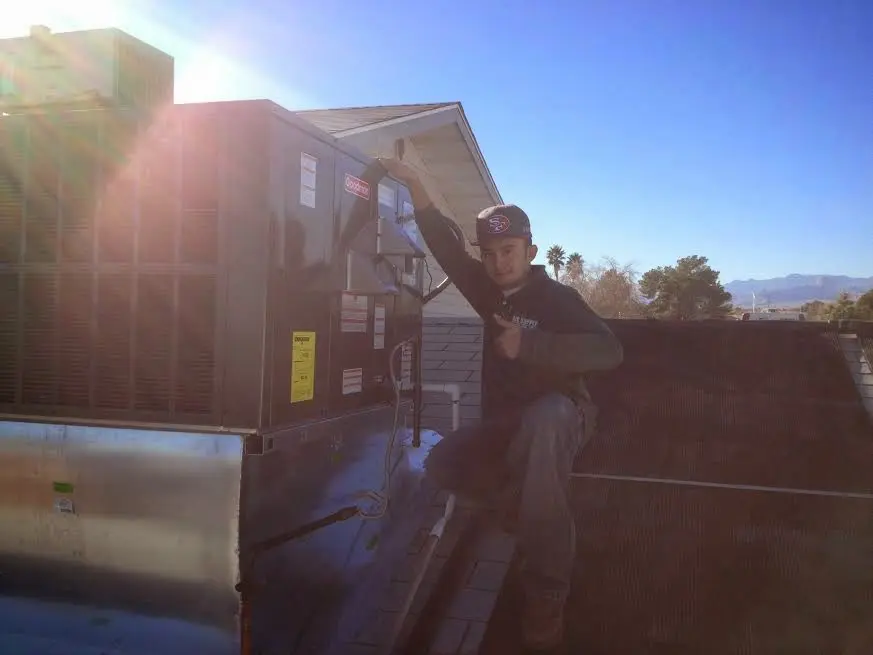 HVAC technician performing Boiler Repair on a rooftop unit in Medina